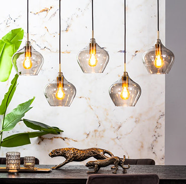 image cut out on white background of 5 smoked glass pendant lights hanging from a black bar