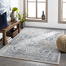 image of vintage grey-blue patterned rug on dark wood living room floor in front of side table and windows with light streaming through