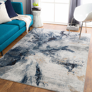image of blue abstract marbled rug on light wood flooring in front of sofa