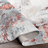 image of grey and red marbled abstract rug folded slightly to show its pile