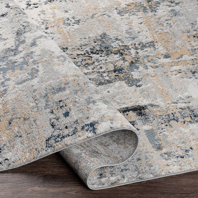 close up image of grey marbled abstract rug with shades of beige and blue