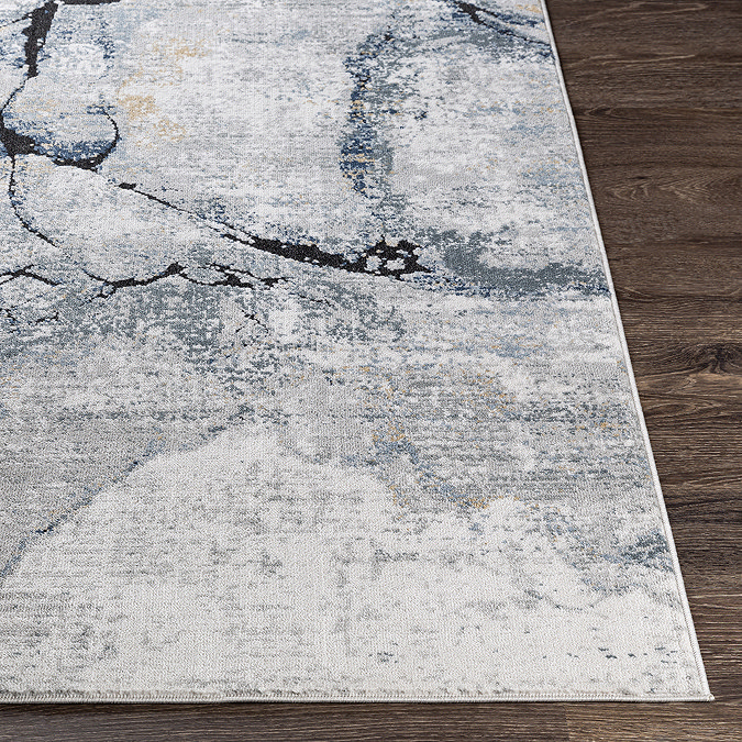 close up image of corner of blue-grey abstract lined rug