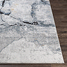 close up image of corner of blue-grey abstract lined rug