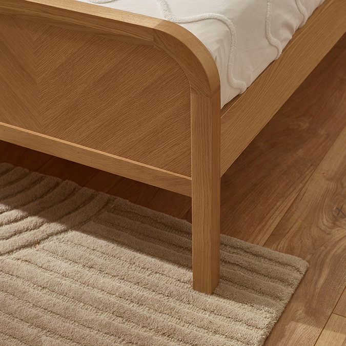 close up on footboard of light oak chevron bed