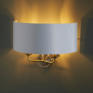 image of two arm light with antique brass arms on dark wall emitting a warm glow