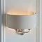 side image of curved fabric wall lamp with 2 chrome arms on a white wall