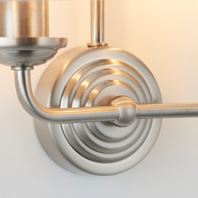 close up image of chrome coloured arms of a wall lamp