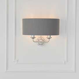 wall light with charcoal shade and 2 nickel coloured arms on cream wall