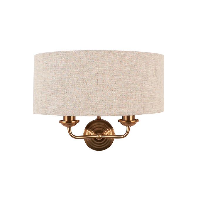 image cut out on white background of wall light with linen shade and 2 vintage brass coloured arms