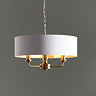 image of antique brass pendant light with white shade hanging in front of mid-grey wall