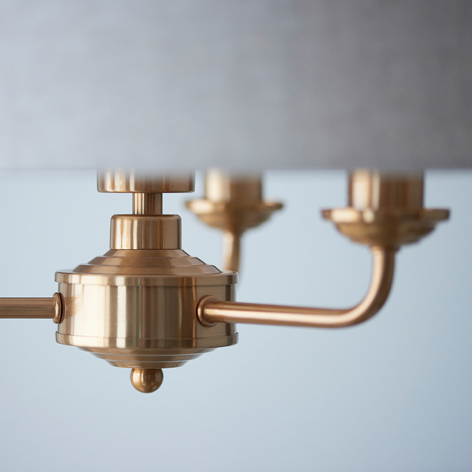 close up on brass metalwork of three arm pendant ceiling light