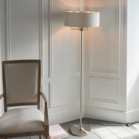 image of chrome-body floor lamp with natural coloured shade propped up by three arms