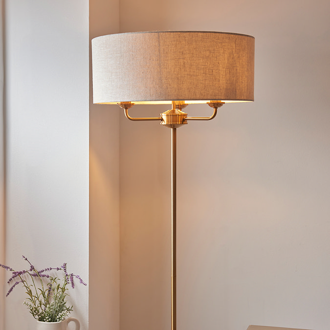 close up image on linen shade of vintage brass floor lamp, with slim body and 3 arms