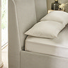 close up on upholstered material of head of beige ottoman bed