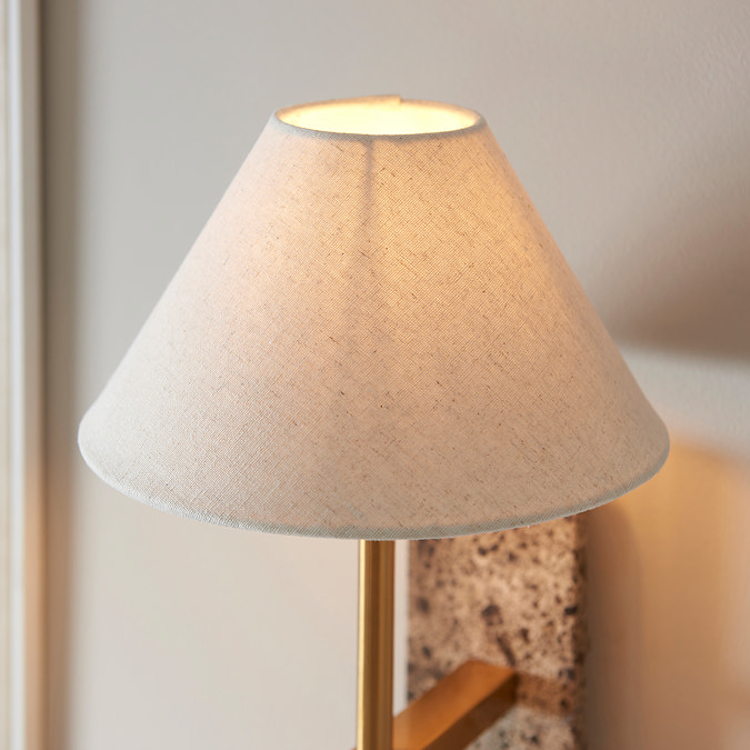close up on tapered natural shade of marble and brass wall light