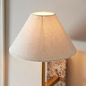 close up on tapered natural shade of marble and brass wall light