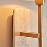 close up image of travertine backplate of brass plated wall light