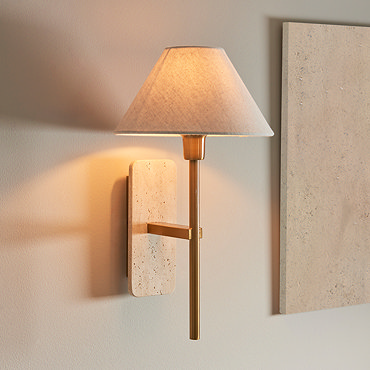 close up image of tapered linen shade of thin brass coloured wall light