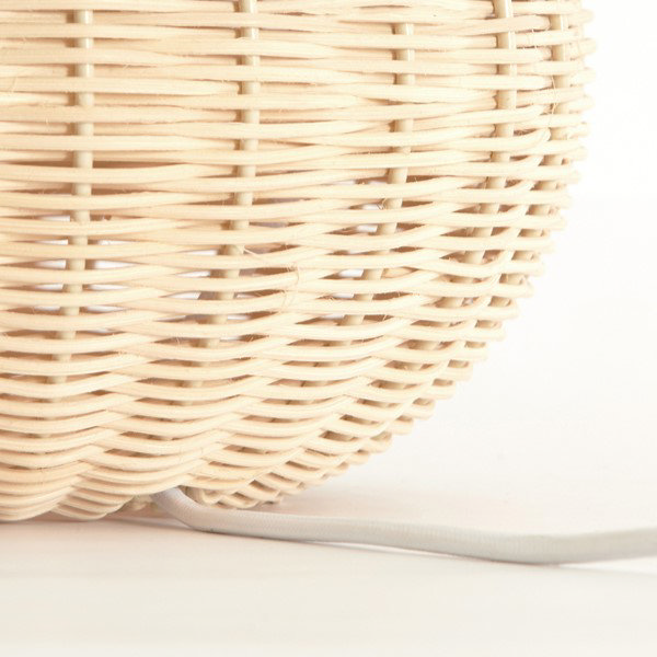 close up image of rounded lower half of natural rattan lamp with white cable attached to the back