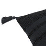 close up image cut out on white background of black textured cushion, focus on one tasselled corner