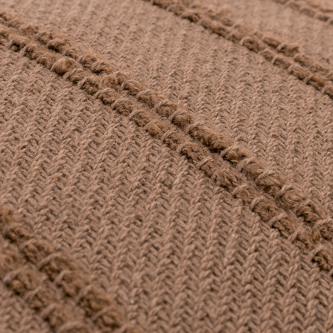 close up image of texture of warm brown square cushion