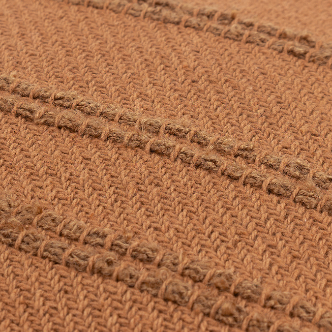 close up image of dark orange tufted stripe cushion
