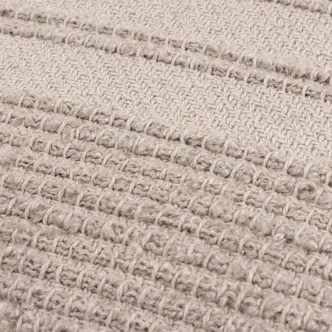 close up image of tufted front of stone coloured cushion