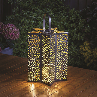 image of tall star shaped lantern with handle and small holes emitting warm light