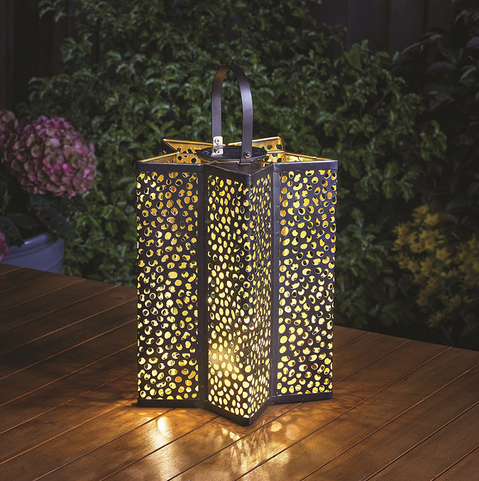 image of tall star shaped lantern with handle and small holes emitting warm light
