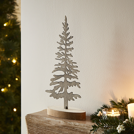 large rustic silhouette tree on a wooden stand, displayed on a light oak mantlepiece.