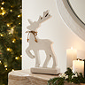 large white wooden standing reindeer on light oak mantlepiece