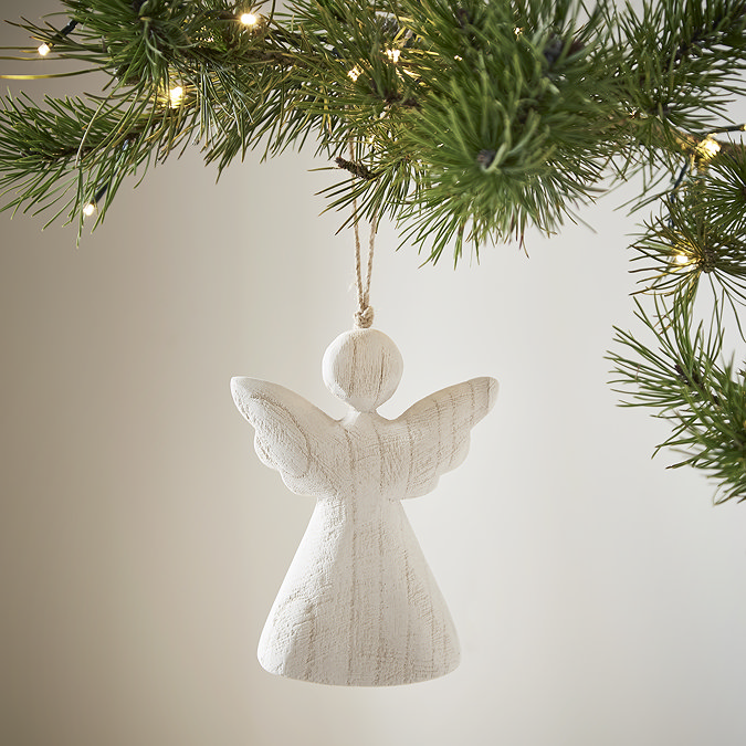 large white wood angel decoration, hanging from a christmas tree