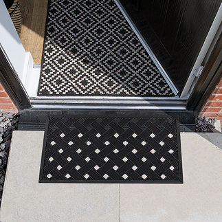 image of black and white latticed rubber scraper mat in front of door