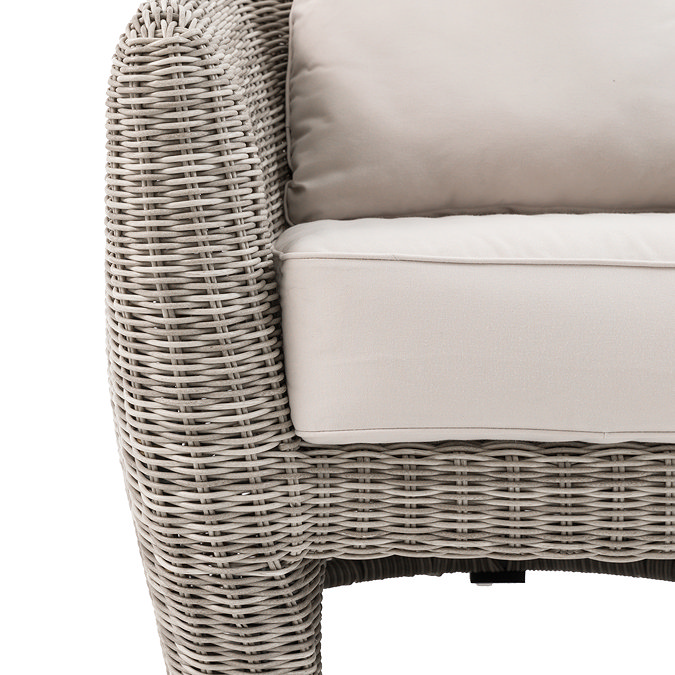close up image of plush cream cushion of rattan garden armchair