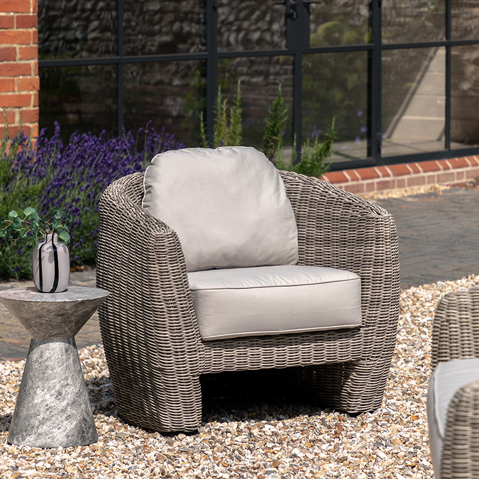 image of single seat garden armchair with rattan frame, slightly curved, and plush cream back and seat cushions