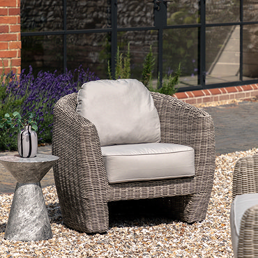 close up image of rattan frame and plush cream cushion of garden armchair