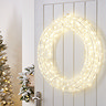 acrylic LED wreath hanging on a white door inside