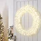acrylic LED wreath hanging on a white door inside