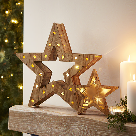 Set of 2 Christmas star decorations, the smaller of which fits inside the larger, and contains an intricate woodland scene lit up by warm white LEDs at its centre.