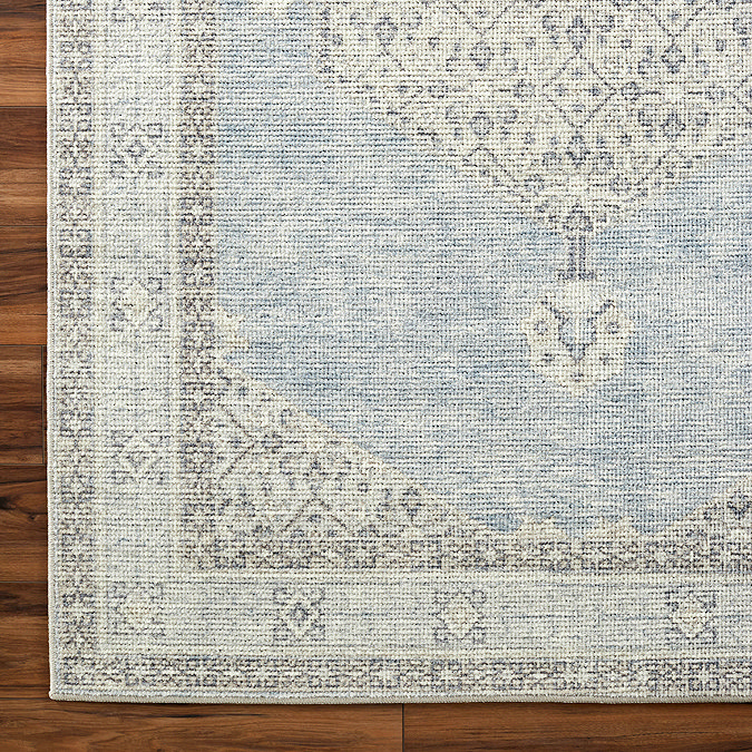 close up image of vintage rug in white and blue, focus on colour and texture