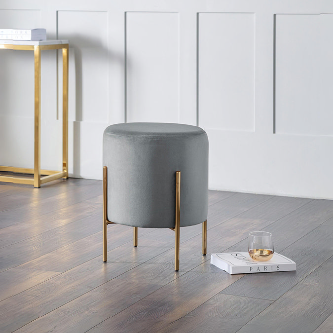 image of velvet grey with gold legs, stool on dark wooden floor