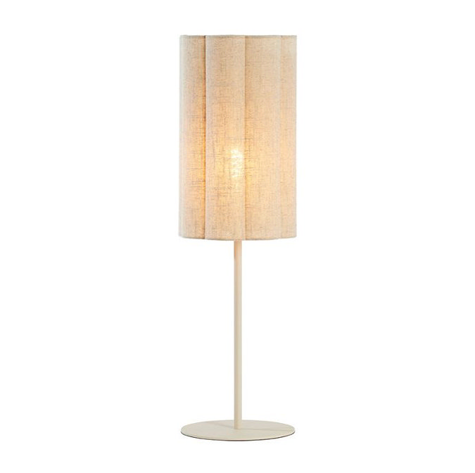 image cut out on white background of linen cylindrical table lamp with bulb emitting a warm glow