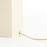 close up image of base of cream linen lamp where cable connects