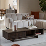 angled image from the side of rectangular walnut coffee table in front of sofa on cream rug, with one drawer and open shelf space