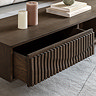 close up image on walnut coffee table with wave-panelled drawer pulled out to suggest inner storage space