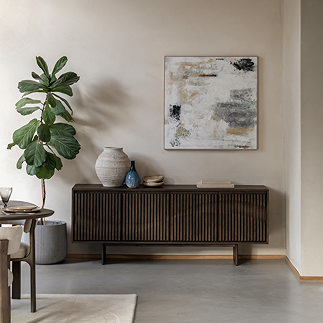 image of walnut 4 door sideboard with wave panel pattern, against a cream wall with neutral abstract art hanging above it