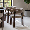 image of natural rounded dining chair with ash wood legs, tucked under walnut dining table