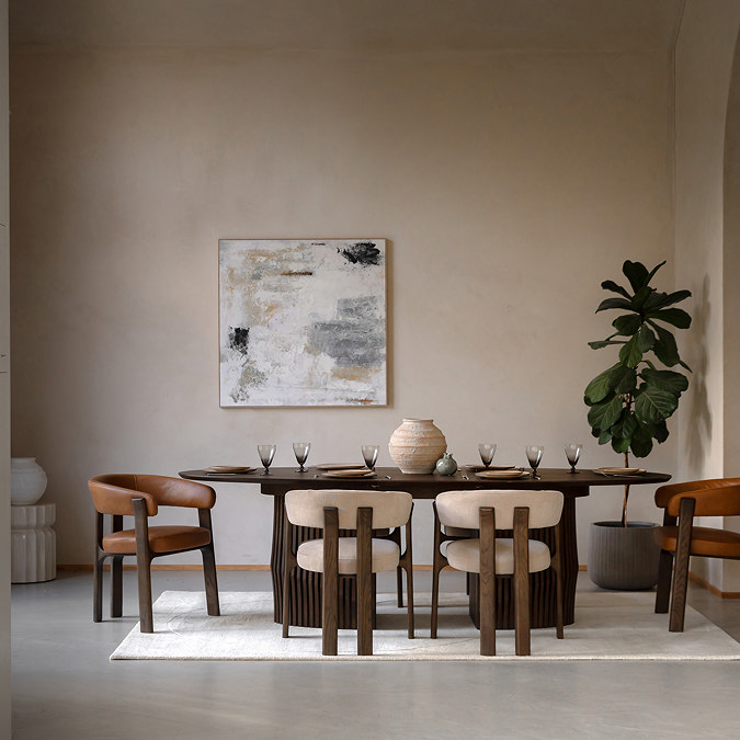 wide image of large oval walnut dining room table with chairs tucked around