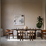 wide image of large oval walnut dining room table with chairs tucked around