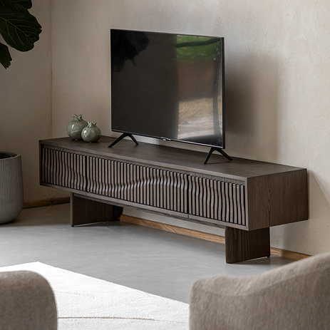 image of walnut coloured wave patterned tv unit with tv on top of it in living room